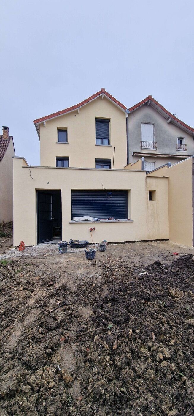 Façade de maison recouverte d'un enduit neuf de teinte sable